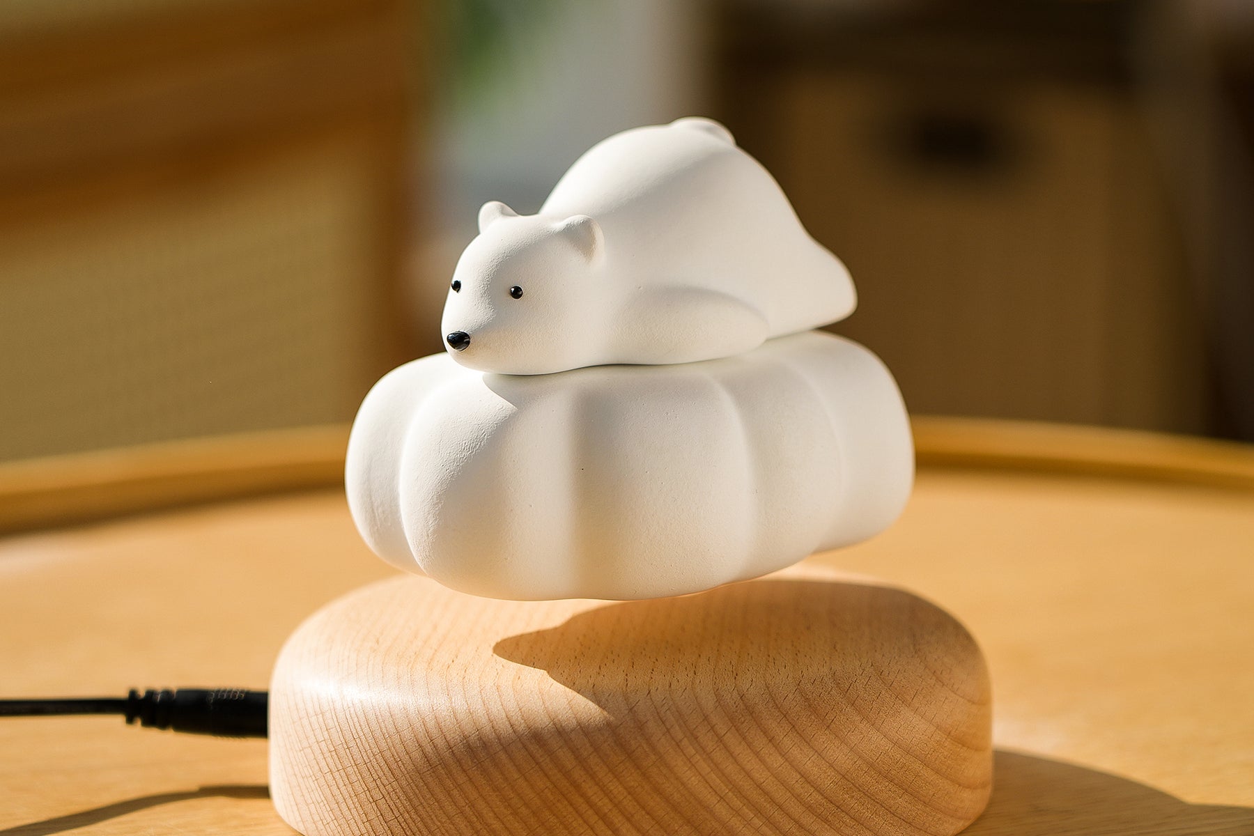 Levitating Polar Bear by Baigu Uncle floating above a quiet wooden base